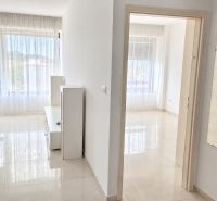 Large windows with white curtains in a bright 2-room apartment with ceramic tiles.