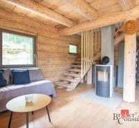 Interior of a family house with a wooden decor floor and a fireplace, solid wood stairs.
