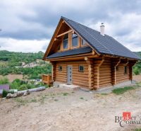 A wooden family house in the village of Vyhne surrounded by nature and hills.