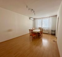 Dining room in a 4-room apartment with a wooden decor floor and a table with chairs.