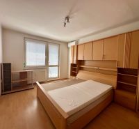 Bedroom in a 4-room apartment with a bed and wardrobes, floor with wood decor.