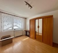 A room with a wooden decor floor, wardrobes, and a large window in a 4-room apartment.