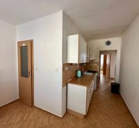 A kitchen in a 4-room apartment with a wooden decor floor and ceramic tiles.
