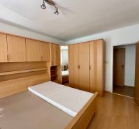 A bedroom with a bed and wardrobes in a 4-room apartment with a wooden decor floor.