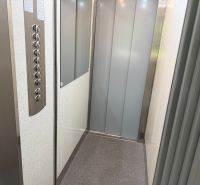 The interior of an elevator with buttons and a mirror in a 2-room apartment.