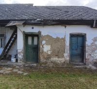 A family house in Opatovská Nová Ves with peeling walls and stairs to the attic.