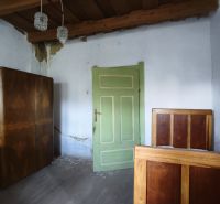 A room in a family house with a wooden ceiling and green doors.