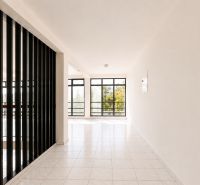 A bright room with large windows and black vertical bars.