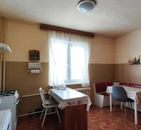 A kitchen in a family house with a dining area and a floor with a wooden decor.
