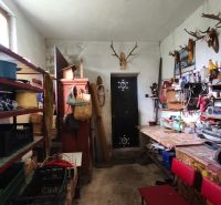 Storage space with shelves and tables in a family house, decorated with antlers on the wall.