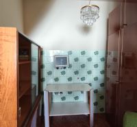 A room with a mirror, a cabinet, and patterned tiles in a family house.