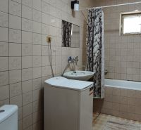 Bathroom with a bathtub, sink, and washing machine in a family house.