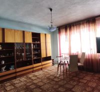 Living room in a family house with a showcase, dining table, and television.