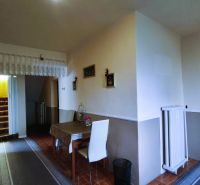 Dining area with white chairs and stairs in a family house.