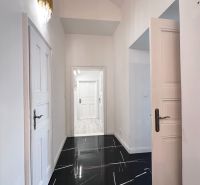 A hallway in a 3-room apartment with glossy tiles and stylish lighting.