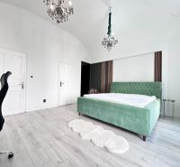 Bedroom in a 3-room apartment with a bed, green curtains, and a wooden decor floor.