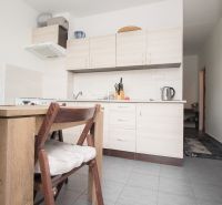A kitchen in a 3-room apartment with a wooden table, light cabinets, and appliances.