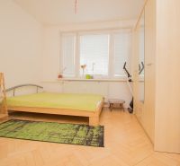 A bedroom with light furniture, a bed, and a wooden decor floor in a 3-room apartment.