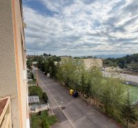 View from a 1-room apartment on Školská Street in Kanianka with a playground and sky.