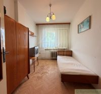 A simple room in a family house with a bed and a wooden decor floor.