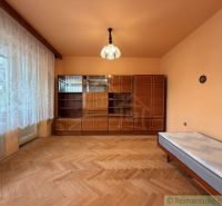 A room with a wooden floor decor, a wardrobe, and a bed in a family house.