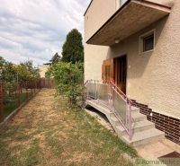 A family house in Nové Zámky with a garden, stairs, and a fence, surrounded by greenery.