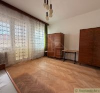 A room with a wooden floor decor, retro furniture, and hanging curtains in a family house.