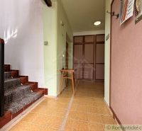 A hallway with wooden stairs and light walls in a family house.