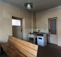 Family house kitchen with a stove and wooden furniture.
