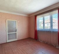 An empty room in a family house with a floor and patterned wallpaper.