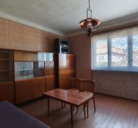 A room in a family house with furniture, armchairs, and a table, with wooden floor decor.