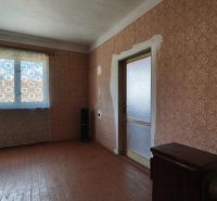 Interior of a family house with brown wallpaper and wood-patterned flooring.