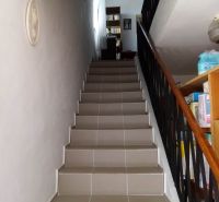 A staircase in a family house with a library on the upper floor.