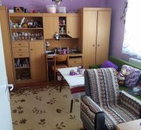 Living room in a family house with purple walls and wooden furniture.