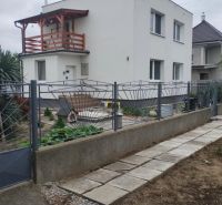 A family house in the city of Trnava with a white facade and a wooden balcony.