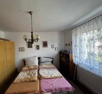 Bedroom with a double bed, chandelier, and curtains in a family house.