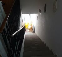 A staircase in a family house with white walls and a railing with a simple design.