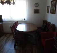 Dining room in a family house with a wooden decor floor, table, and vintage furniture.