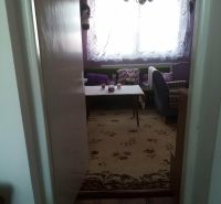 Interior of a family house with a floral carpet and a nicely furnished living area.