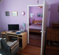 Living room in a family house with purple walls and a wooden-patterned floor.