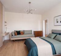 Bedroom in a family house with wood-patterned flooring and comfortable seating.