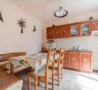 A kitchen in a family house with a table, chairs, kitchen unit, and decorative elements on the wall.