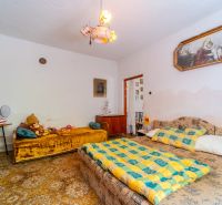 Bedroom in a family house with beds, a wardrobe, carpeted floor, and decorations.