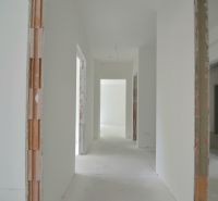 A bright hallway in a 3-room apartment with unfinished walls and a concrete floor.