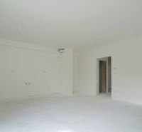 A neutrally toned interior of a 3-room apartment, white wall, preparation for a kitchen unit.