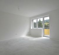 A bright room in a 3-room apartment with large windows and a balcony, overlooking greenery.
