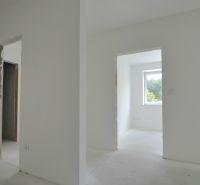 An interior with unfinished door openings and a large window in a 3-room apartment.