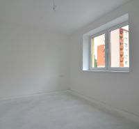 An empty room in a 3-room apartment with white walls and a large window.