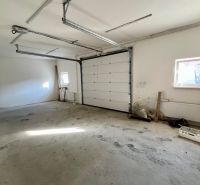 Spacious garage in warehouses and halls with white walls and concrete floor.