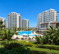Apartments in Bogazi surrounded by greenery with a pool in the center.